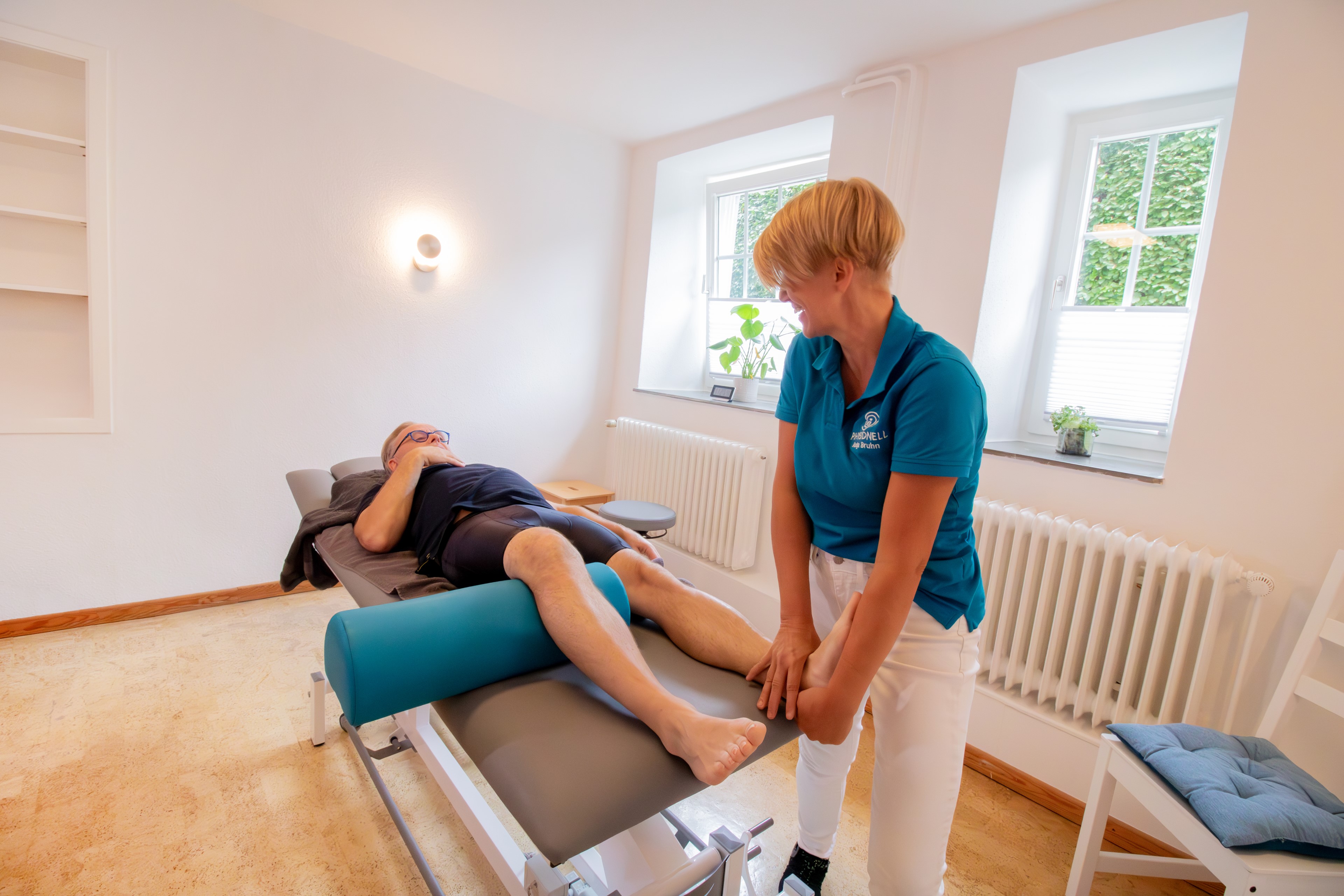 Physiotherapeutin Julia Neelsen behandelt den Rücken eines Patienten.